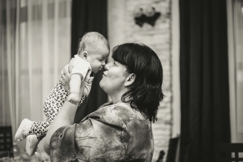 a mother kissing her baby's forehead on a table