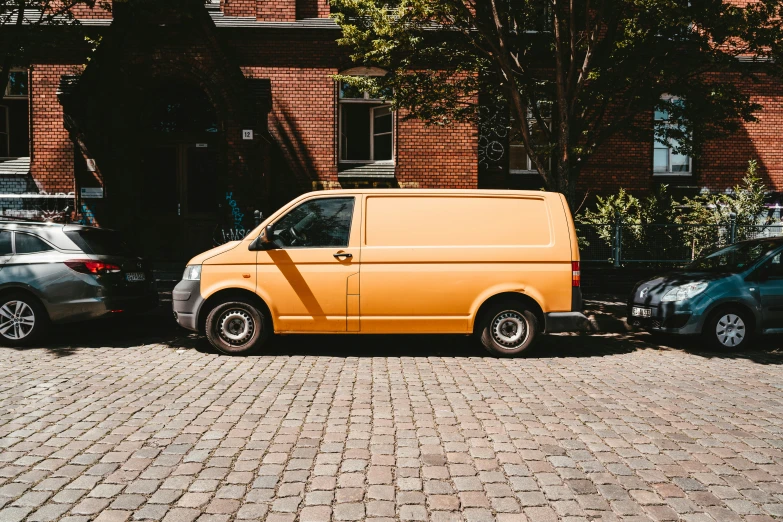 a small orange van on a trailer pulling it