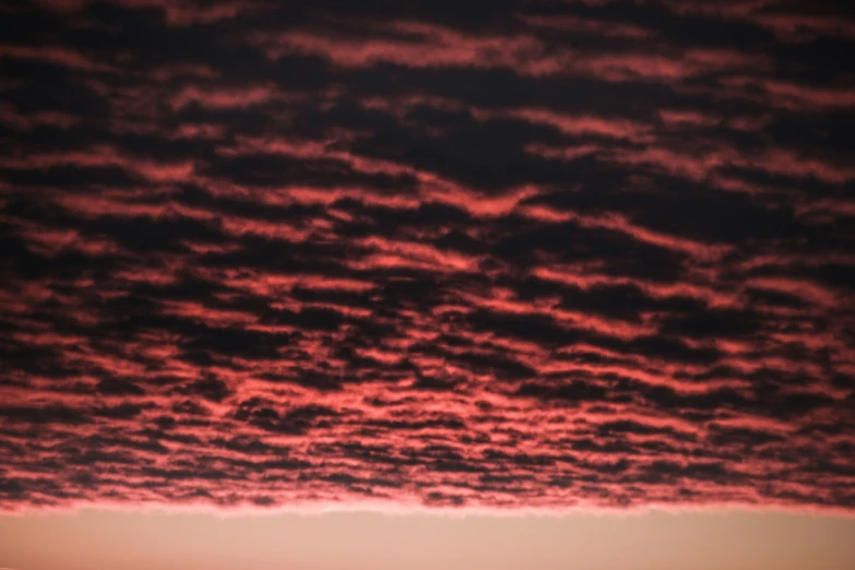 a pink and black sunset sky with red clouds