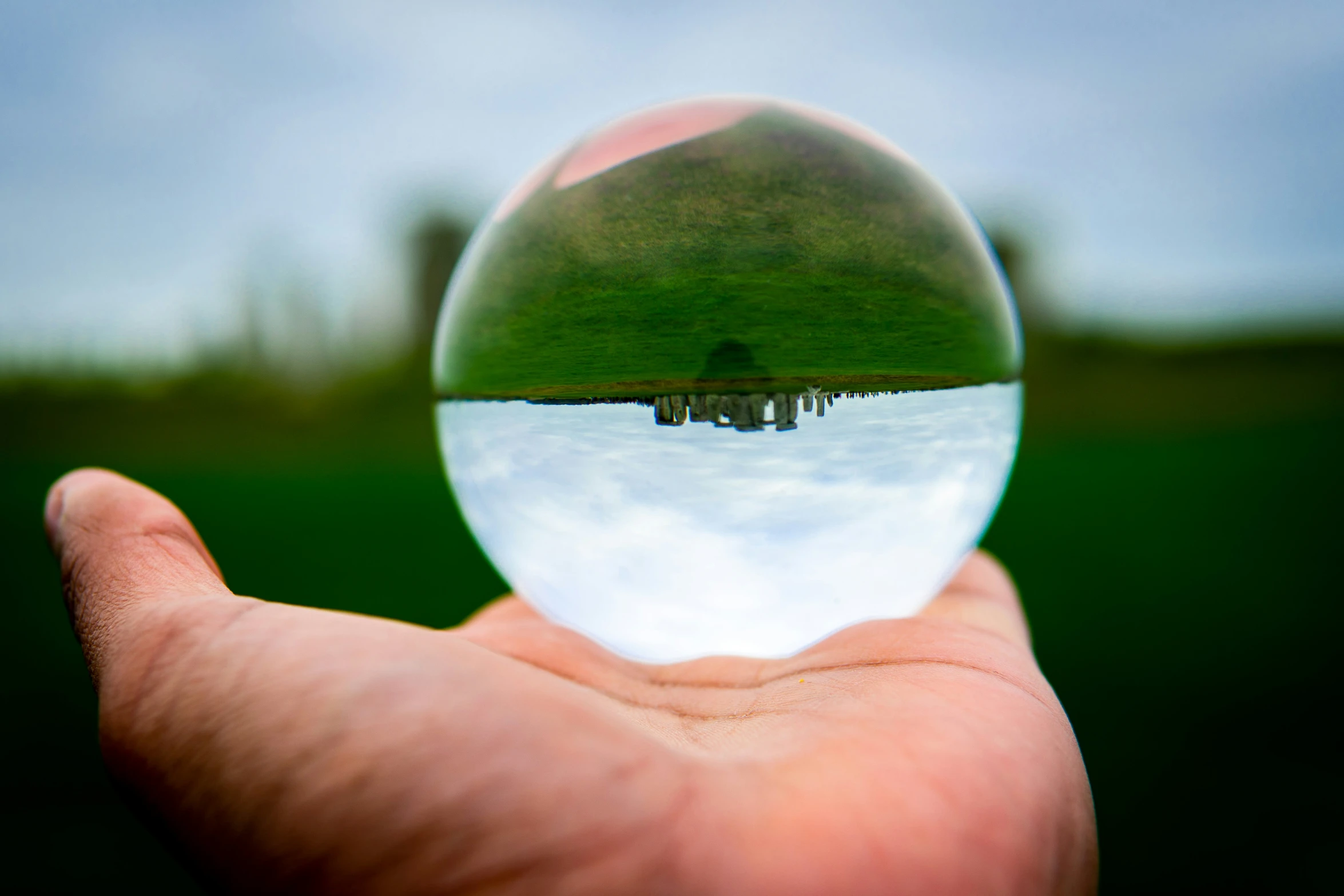 a person holding a half of a clear glass ball