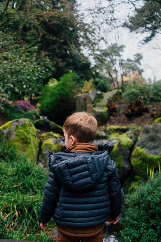 a  walking toward a large rock with a teddy bear