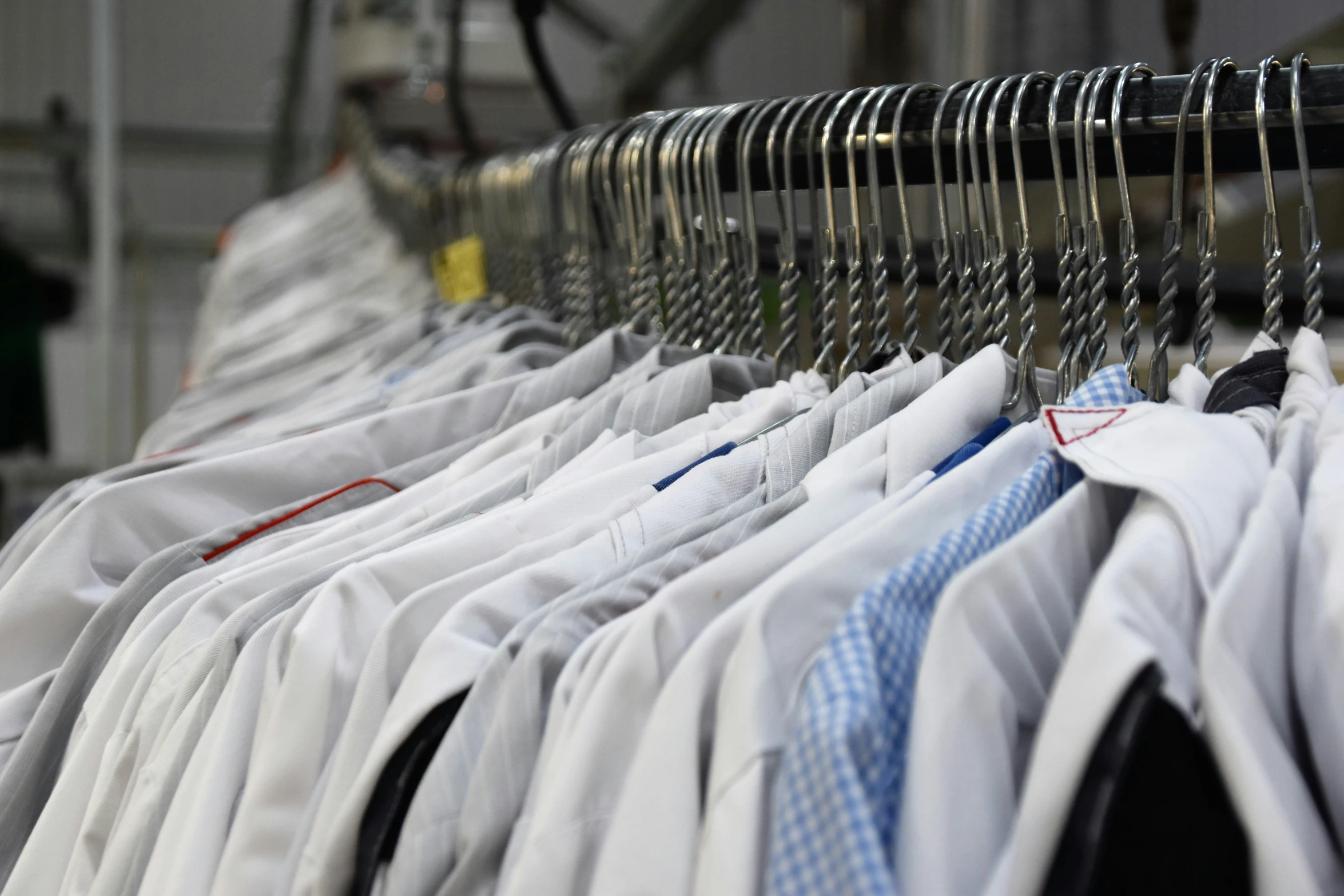 a rack filled with white shirts on hangers