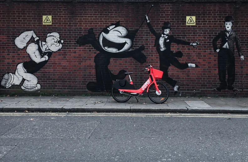 a red bike parked next to a brick wall