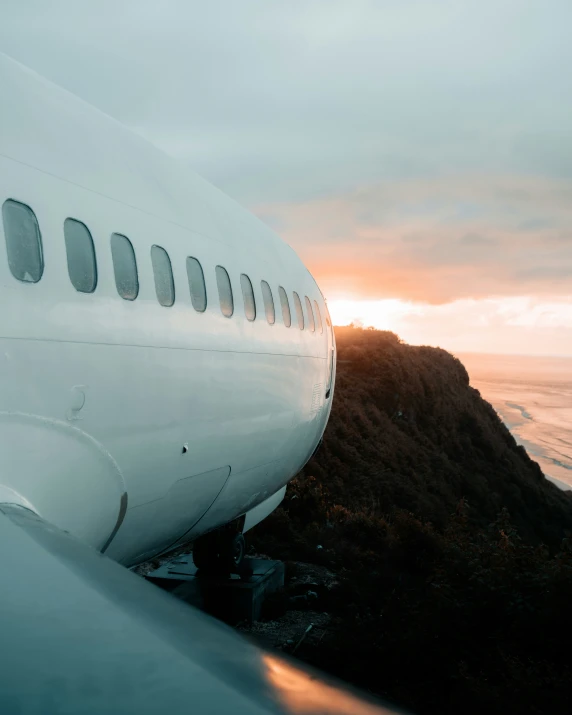 the side of an airplane and a sunset