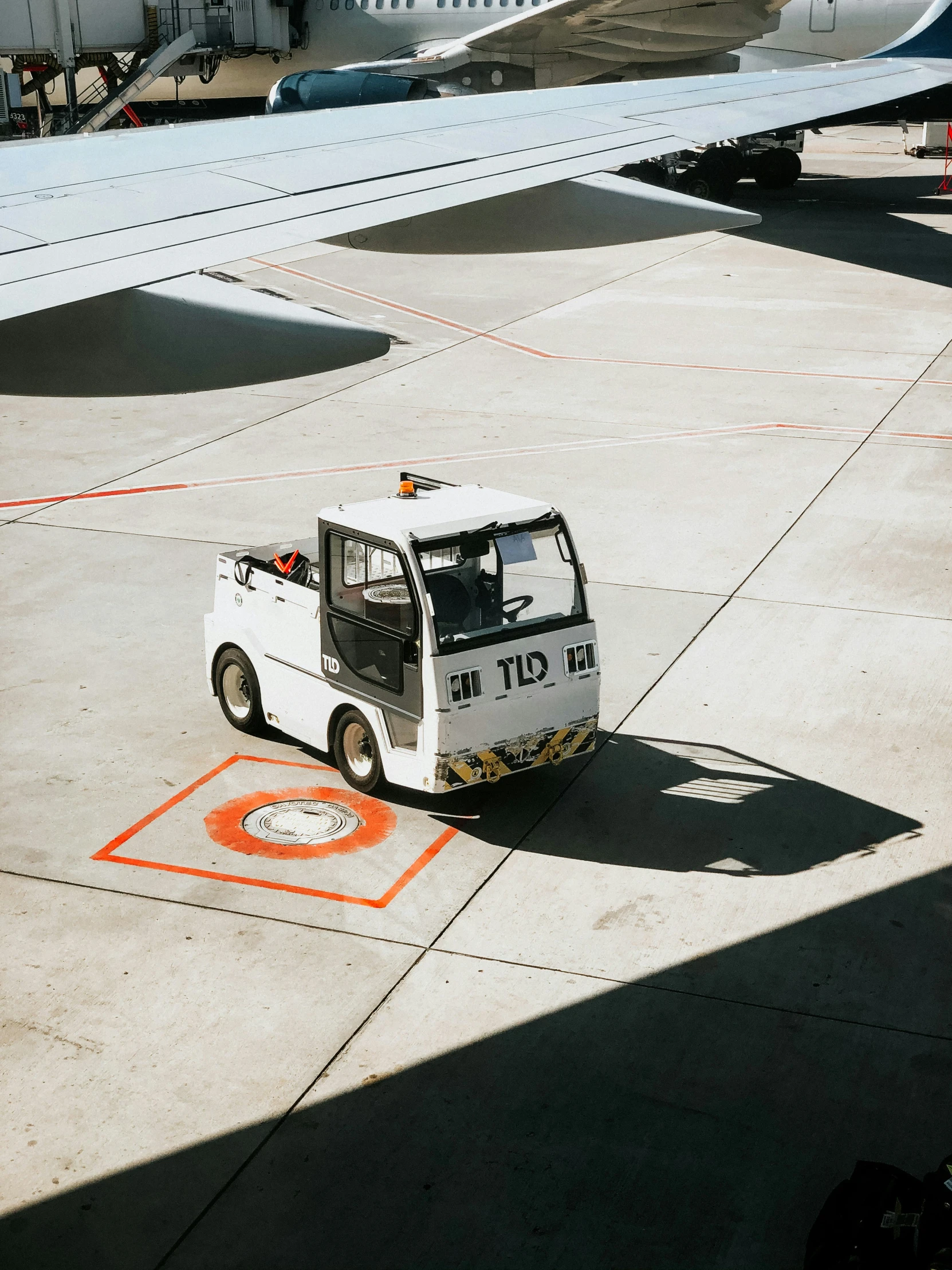 a white cart driving down a runway towards an airport