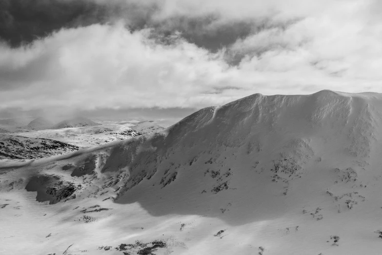 a mountain slope with trees and some snow on it