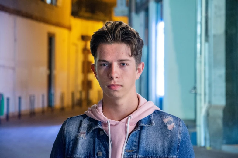 a man wearing blue jeans in the middle of a alley way