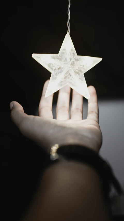 hand holding a star shaped decoration that looks like it is from the movie