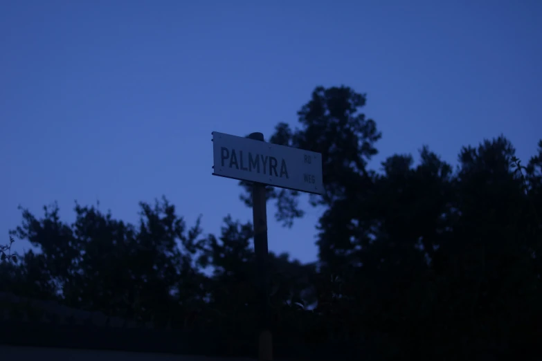 a street sign and trees in the background