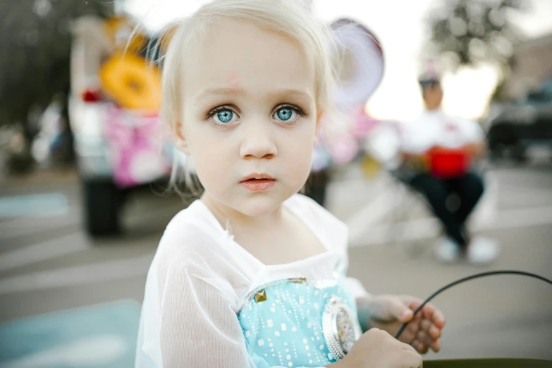 a  with blue eyes holding onto a green bag