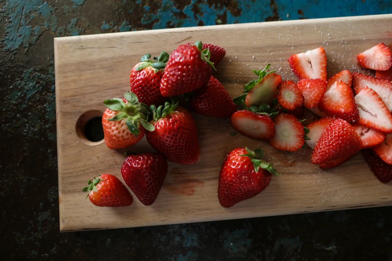 a  board topped with lots of ripe strawberries