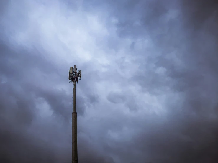 a man works on a cell phone tower