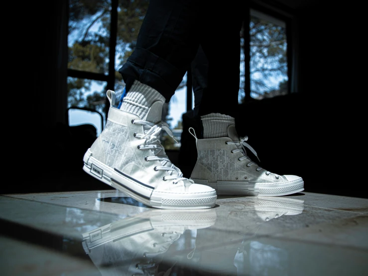 a person in high top sneakers standing on some concrete