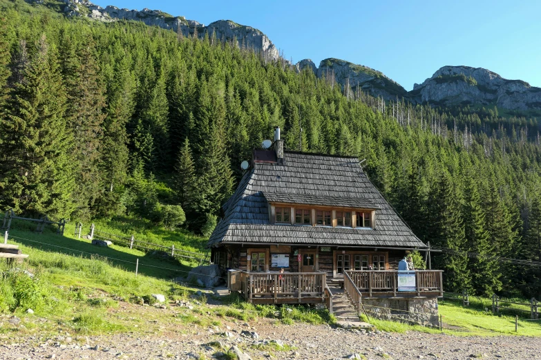 a cabin in the middle of mountains near the woods