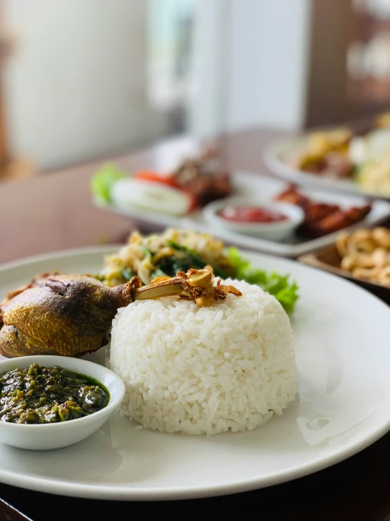 an assortment of asian food including rice and vegetables on a white plate