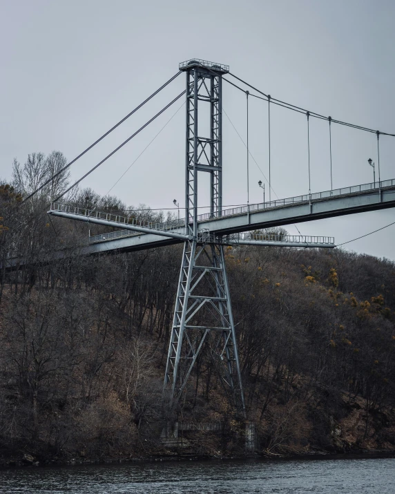 a very tall white bridge over water in a country side