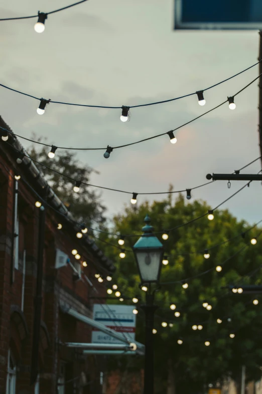 lights strung from a wire and building beside street