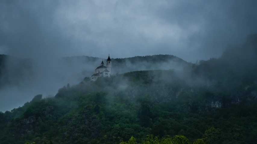 a church atop a hill with dark clouds