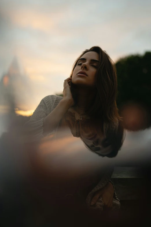 woman looking up at the sky while sitting outdoors