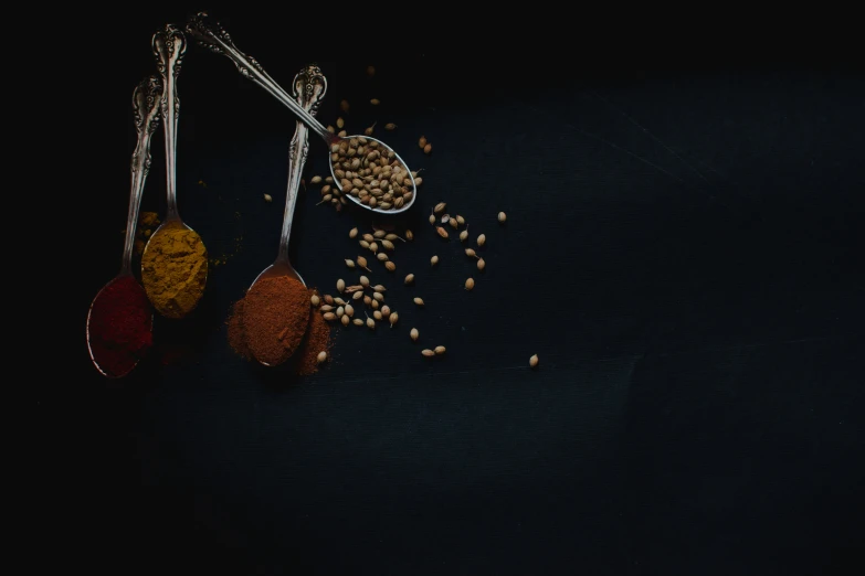 three spoons of grains and one spoon with cereal on the side