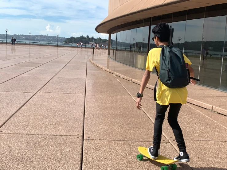 a person riding a skateboard on the pavement in front of a building