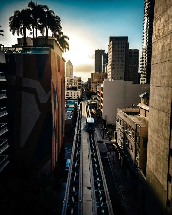 a sun set and the top of an office building and a train going down a track