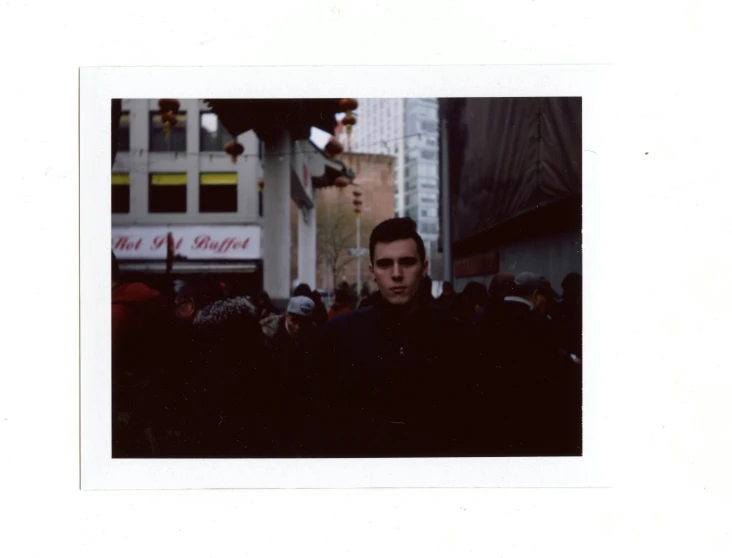 a man walking down a busy street next to tall buildings