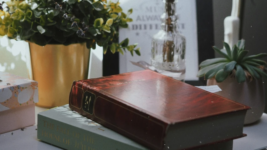 some books are sitting on a table and flowers