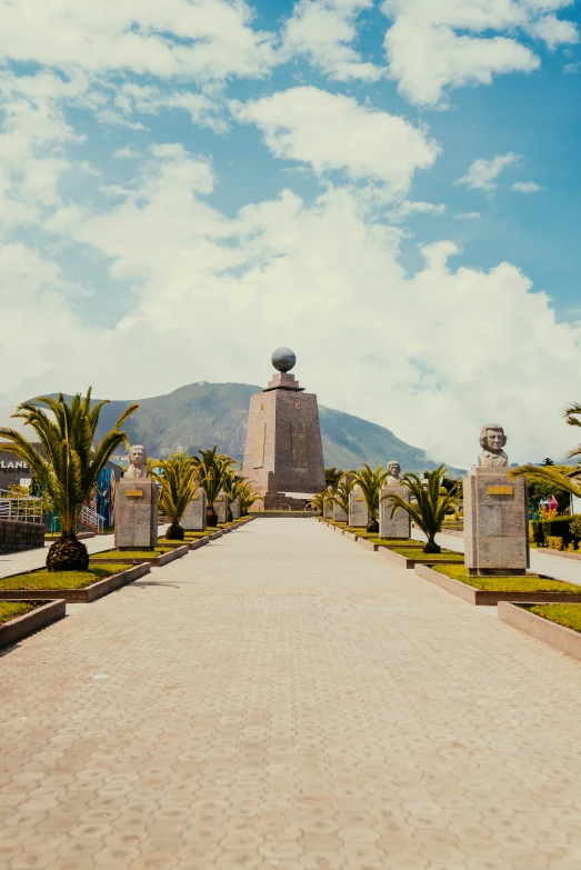 the large white building has many statues on the driveway