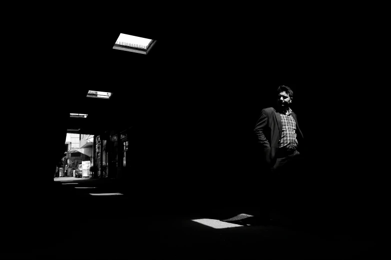 man walking in dark doorway alone in darkened area