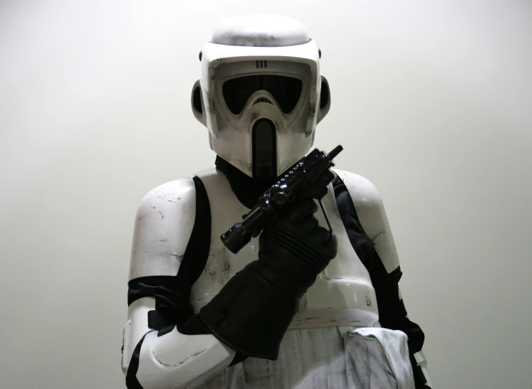 a star wars cosplay dressed in a white uniform and holding a machine gun