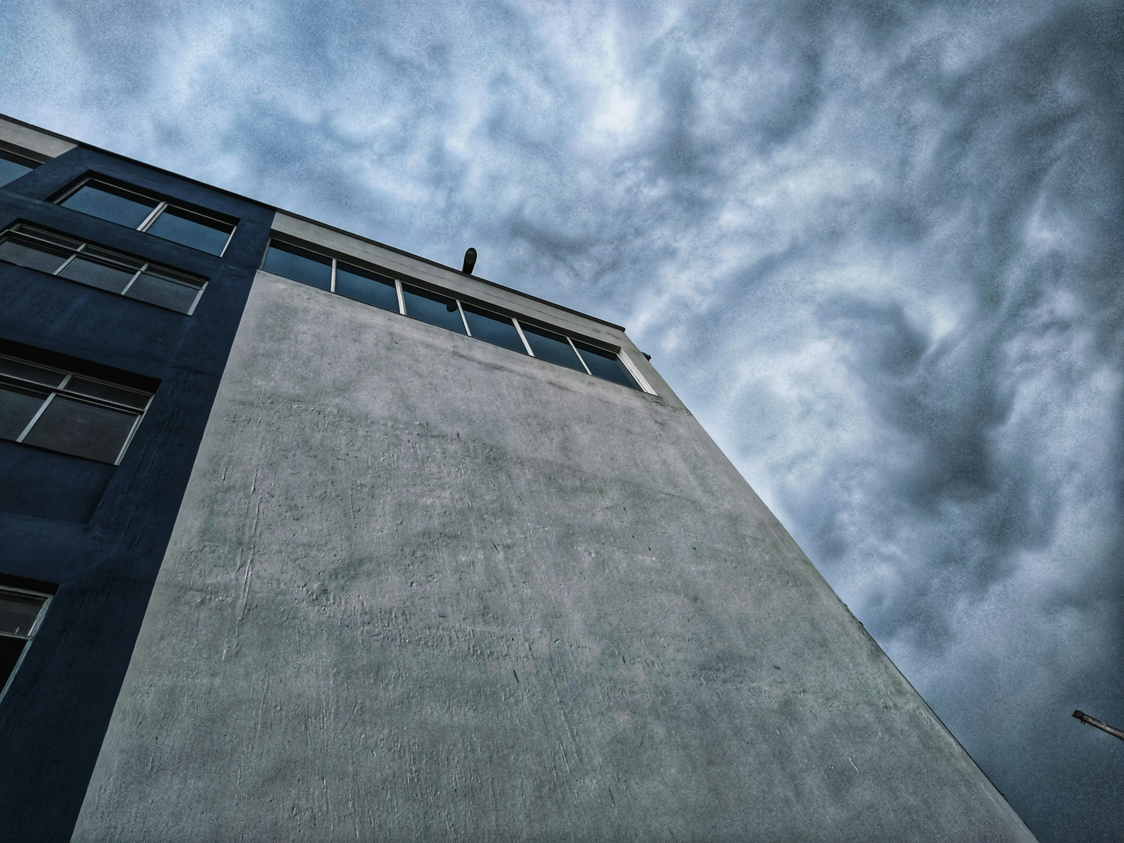 an apartment building is viewed against a blue cloudy sky