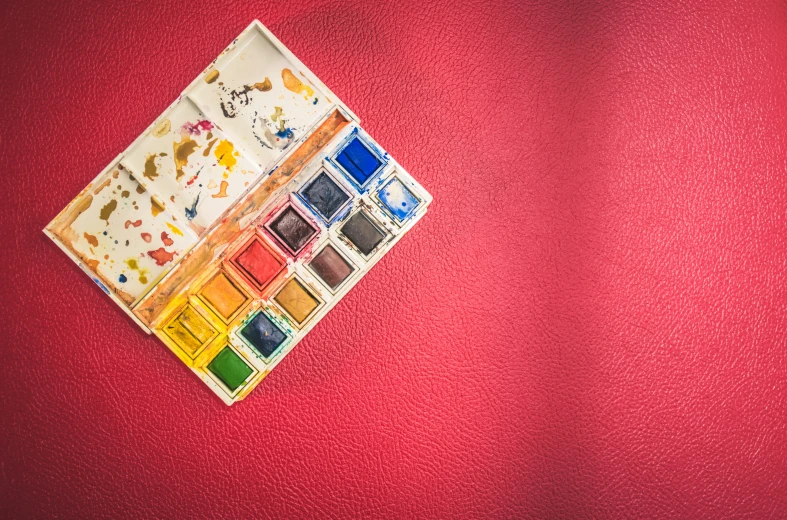 a box of paints sitting on top of a red surface