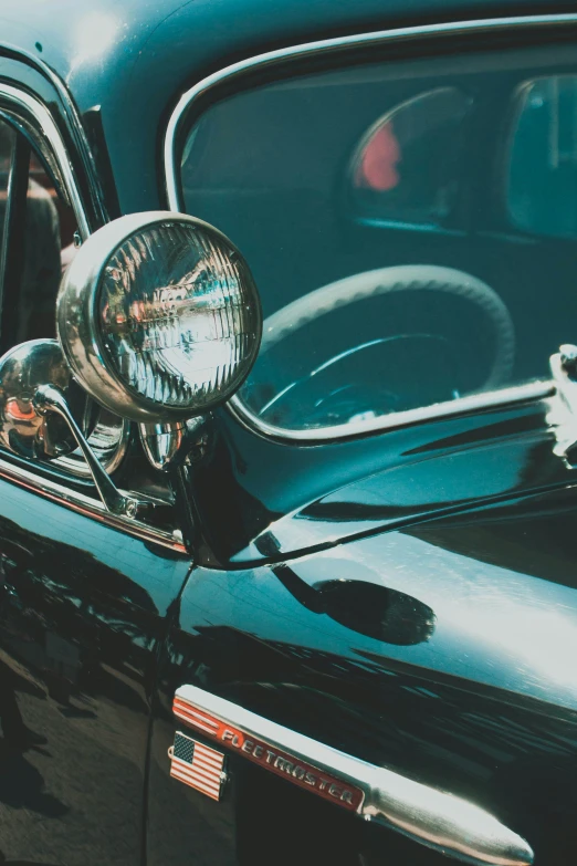 an old time style car with an american flag in the passenger seat