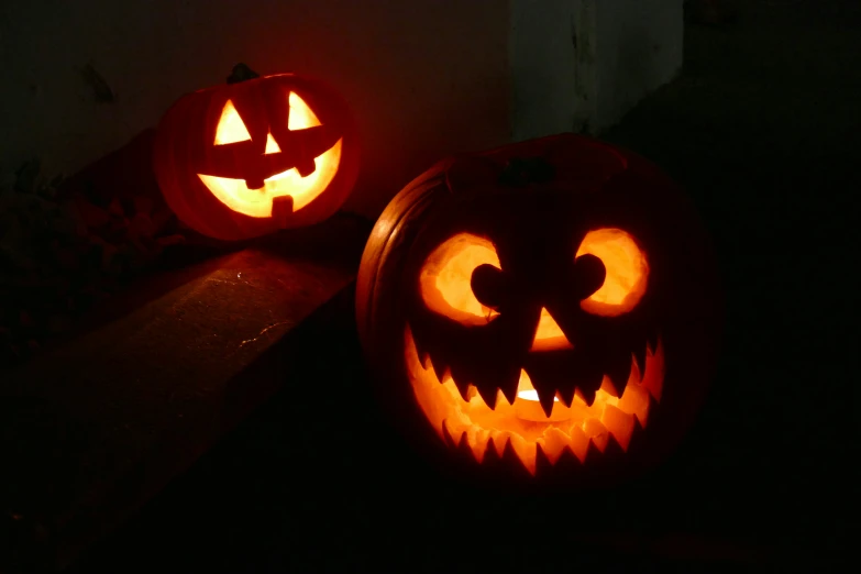 two pumpkins with faces carved into them