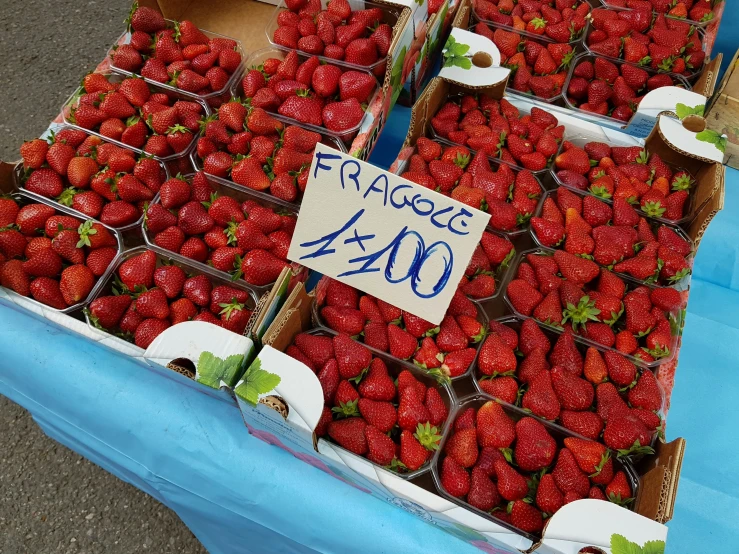 baskets full of strawberries for sale on a table