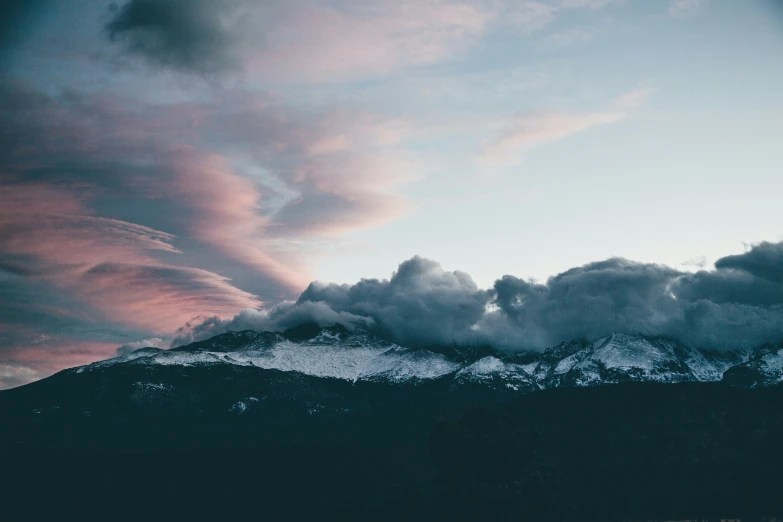 a group of clouds and mountain range in the distance