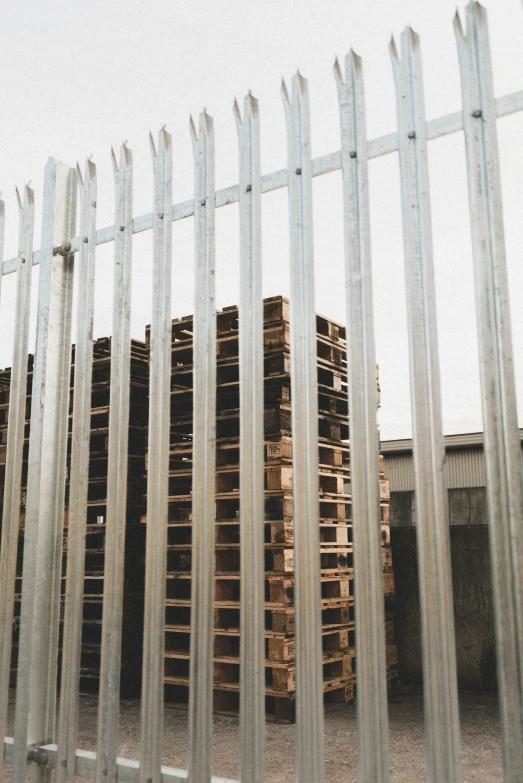 several pallets stacked on top of each other behind a chain link fence