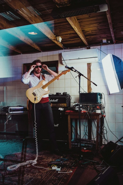 man in a recording studio with a microphone and guitar