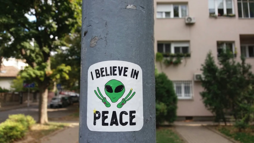the sticker on the grey pole shows the face of an alien