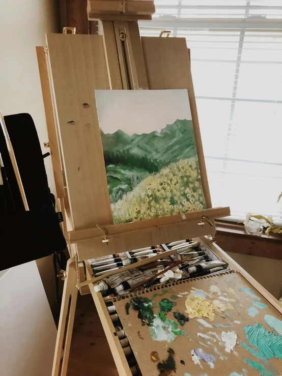 a painting in an easel with a palette and paints