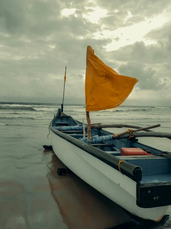 a boat on a wet beach with a flag