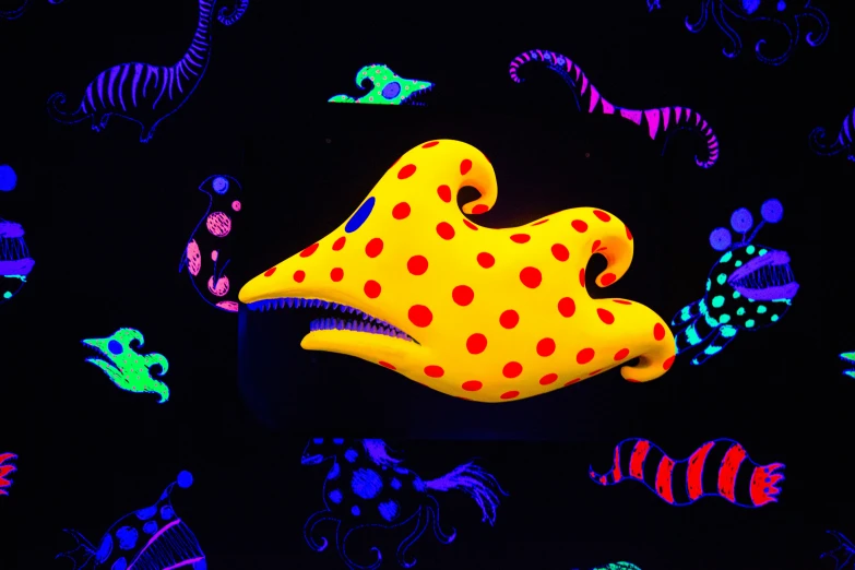 a yellow polka dot stuffed animal is on a black surface