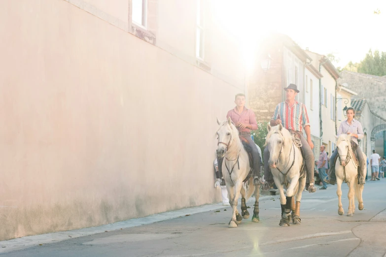 two people are riding on horses down the road