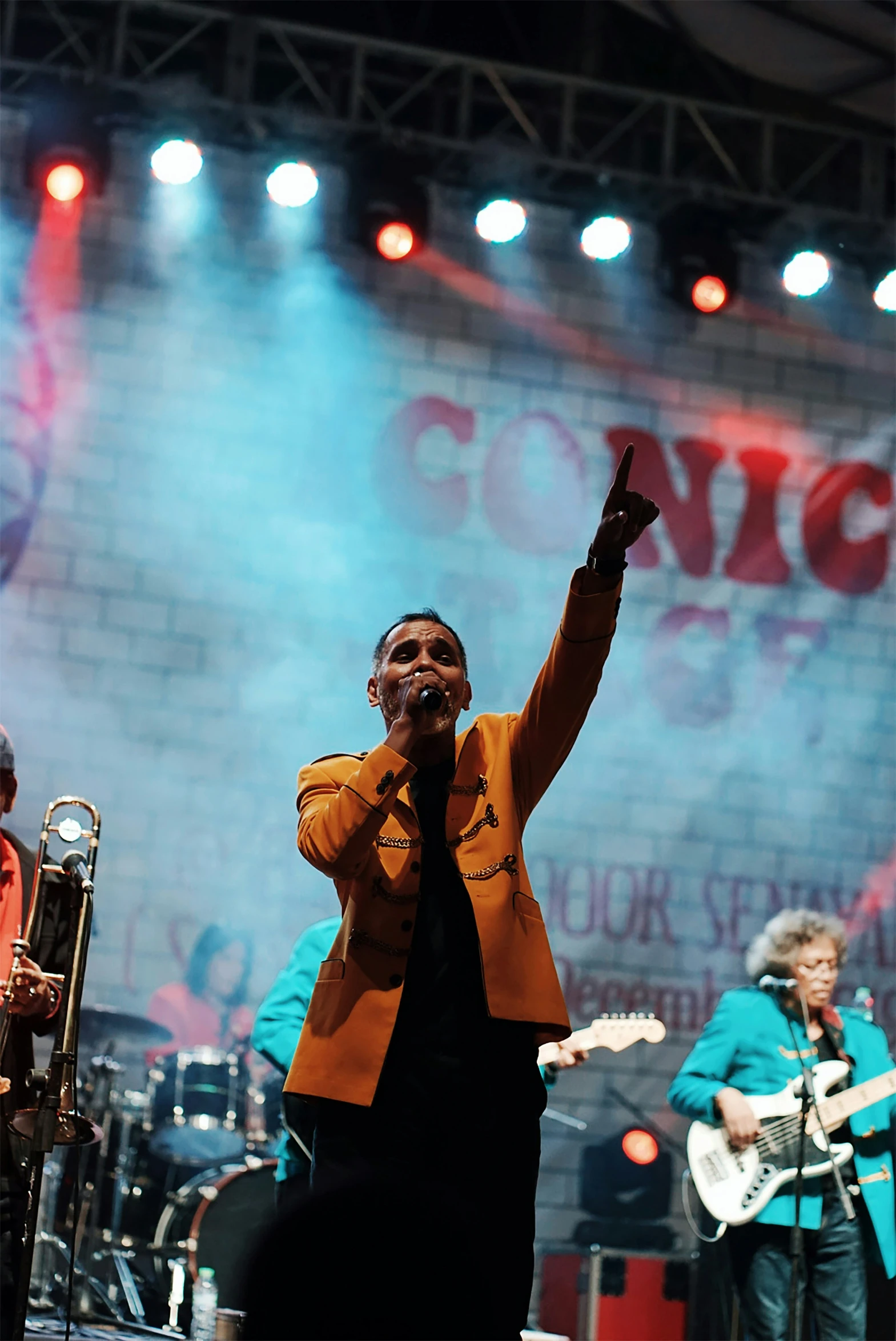 a man is singing into the microphone on stage