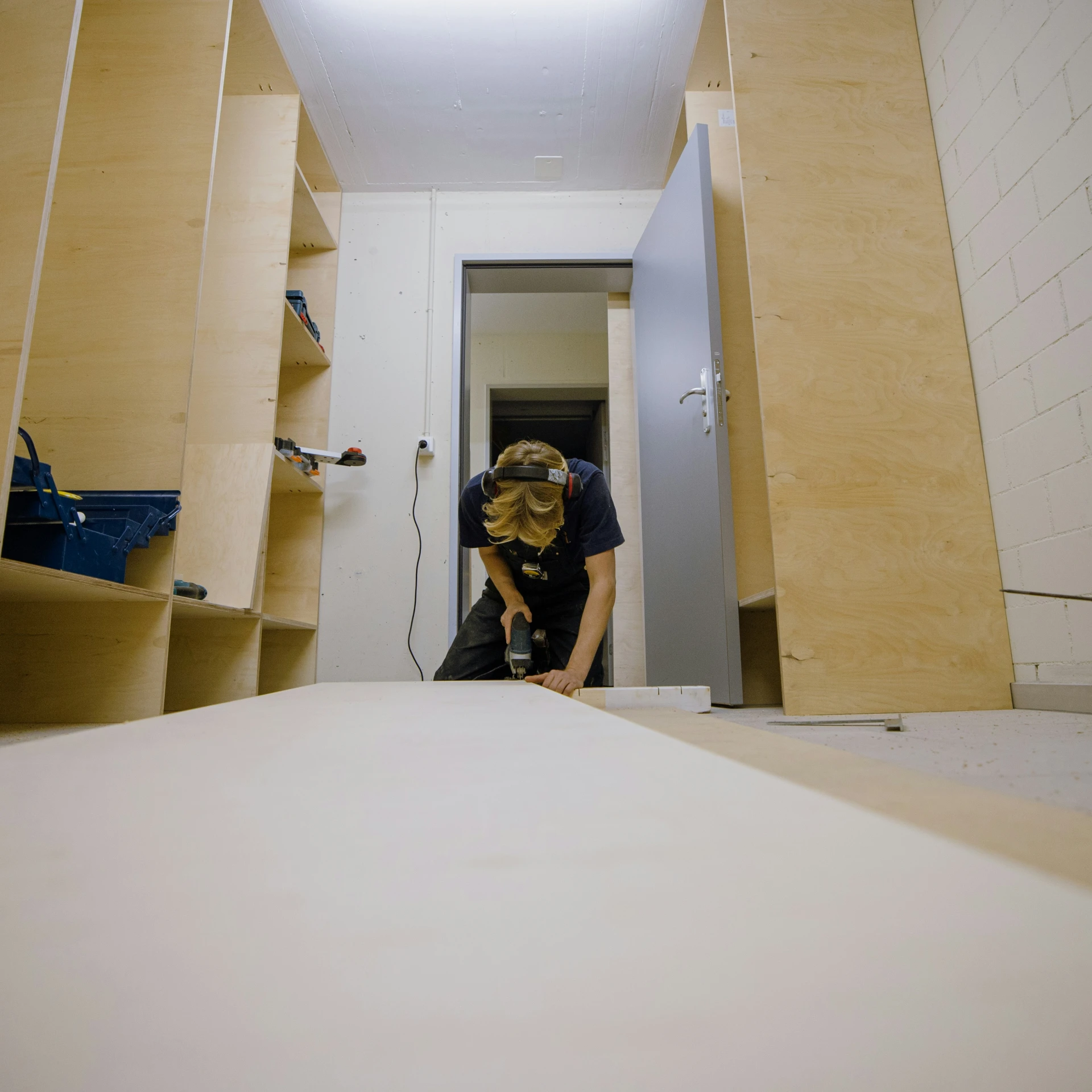 a man standing in a room with a very long wall