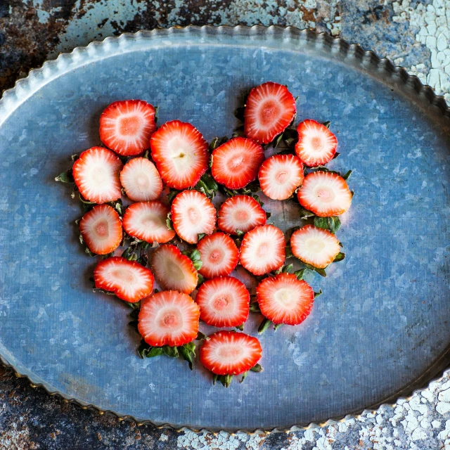 small, round strawberries are on a blue plate