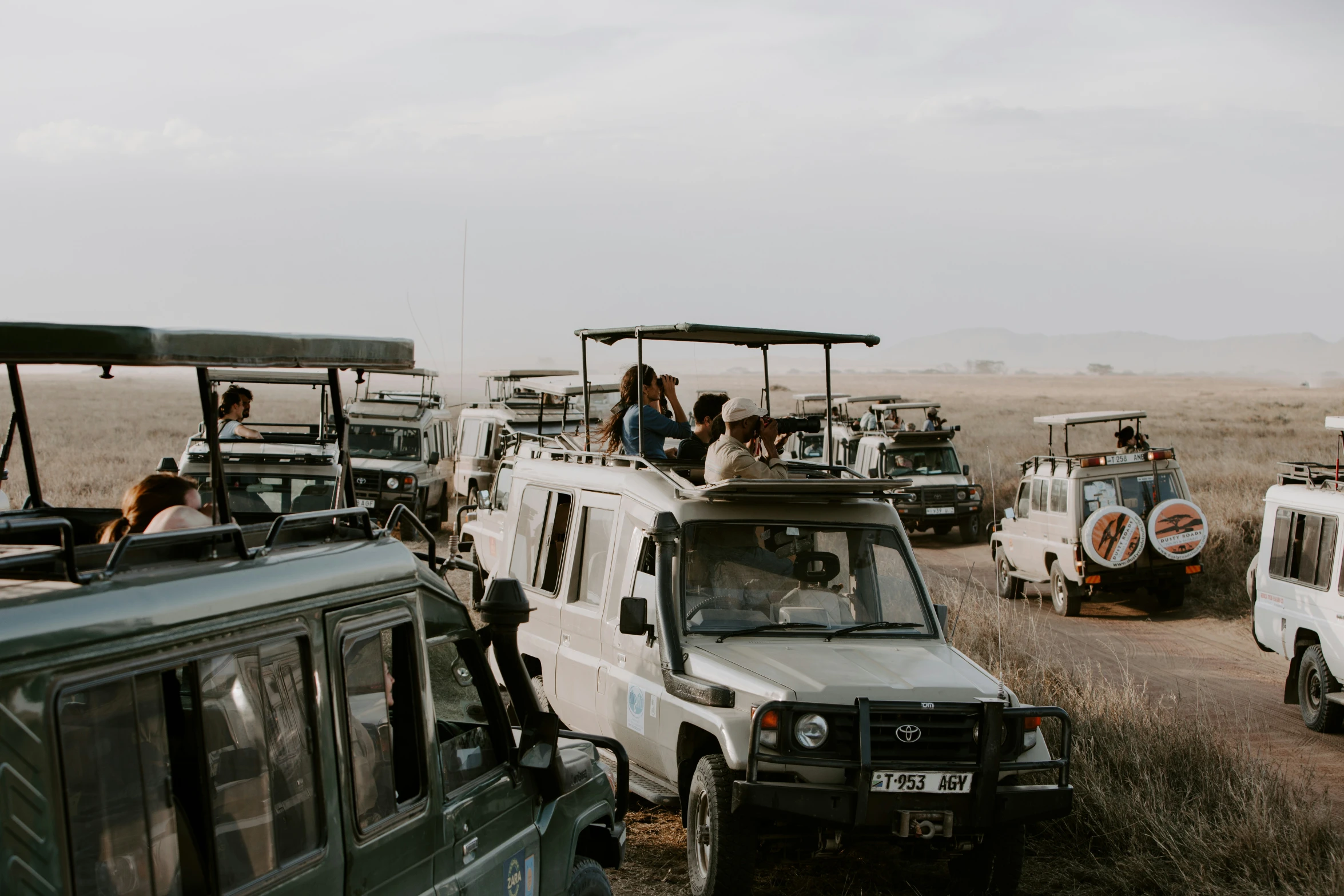 a couple of jeeps parked next to each other on a dirt road