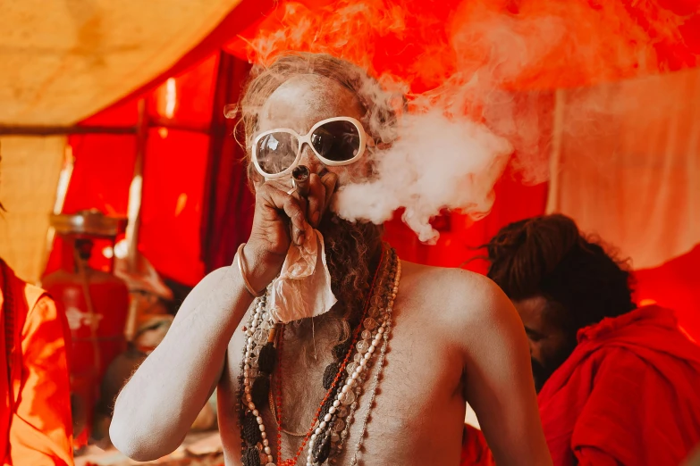 there is a man with very long hair and  wearing a tie smoking