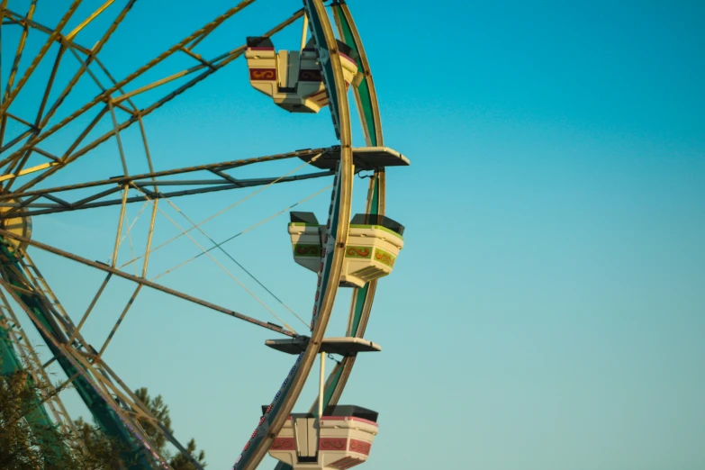 a colorful carnival wheel with trees in the background